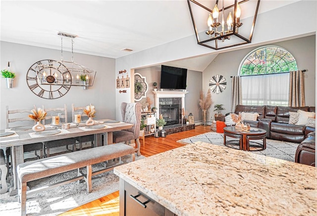 living room featuring a chandelier, light wood finished floors, and a fireplace