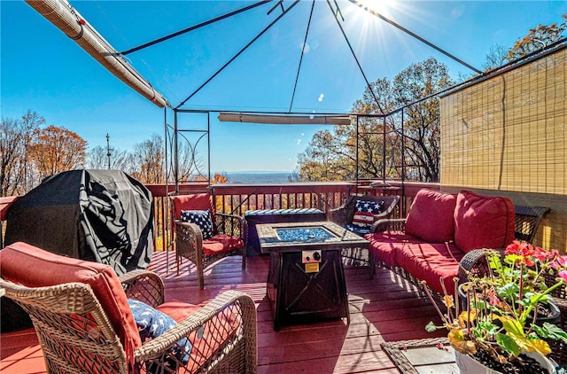 wooden deck featuring an outdoor living space with a fire pit