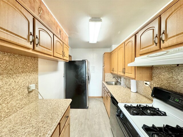 86-15 Broadway Unit 4D, Elmhurst, NY 11373 - kitchen with a sink, stainless steel fridge, light countertops, under cabinet range hood, and gas range gas stove