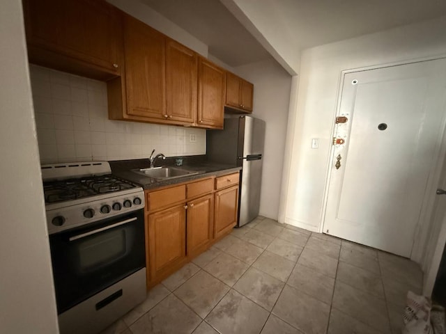34-15 74th St Unit 4H, Jackson Heights, NY 11372 - kitchen with range with gas cooktop, a sink, freestanding refrigerator, dark countertops, and backsplash