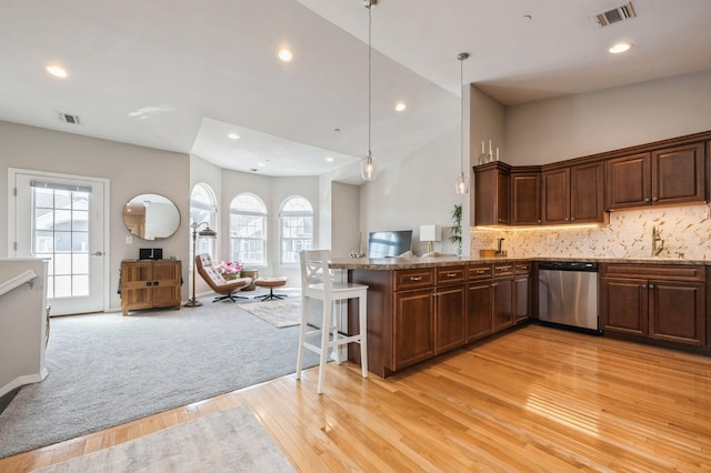 kitchen with open floor plan, light wood-type flooring, visible vents, and stainless steel dishwasher