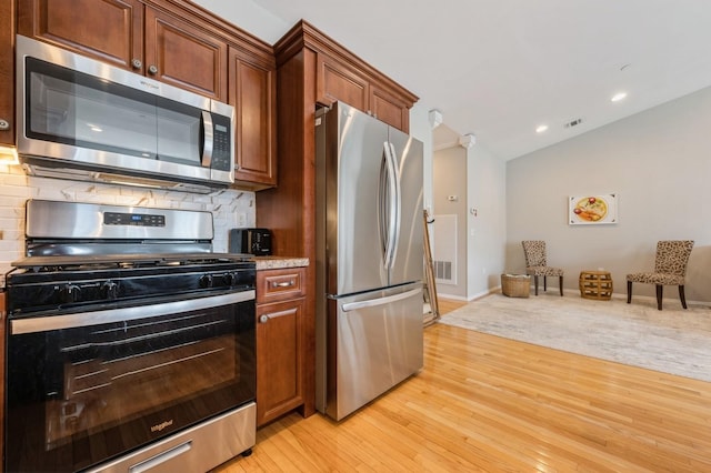 kitchen with recessed lighting, stainless steel appliances, backsplash, visible vents, and light wood-style flooring