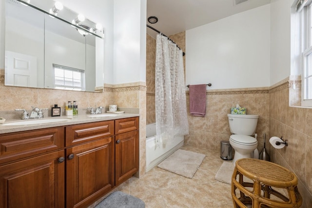 bathroom featuring tile walls, a sink, and toilet