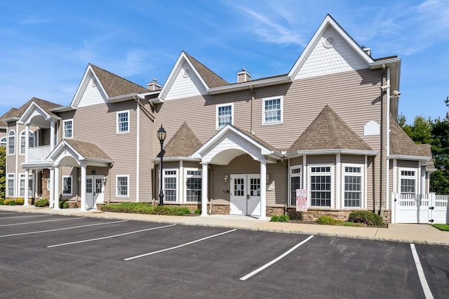 view of building exterior with fence and uncovered parking