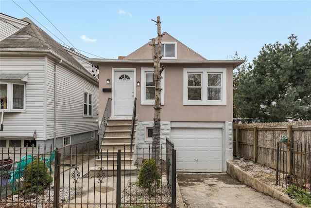 425 Quincy Ave, Bronx, NY 10465 - view of front of property featuring driveway, stucco siding, fence, and an attached garage