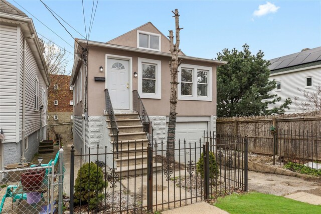 425 Quincy Ave, Bronx, NY 10465 - view of front facade with entry steps, a fenced front yard, a garage, and stucco siding