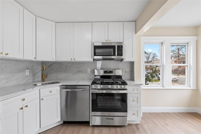 425 Quincy Ave, Bronx, NY 10465 - kitchen with light wood finished floors, a sink, light stone countertops, and stainless steel appliances