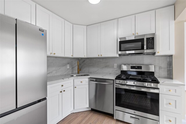 425 Quincy Ave, Bronx, NY 10465 - kitchen featuring a sink, white cabinets, light stone counters, and stainless steel appliances