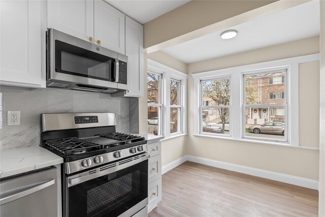 425 Quincy Ave, Bronx, NY 10465 - kitchen featuring baseboards, appliances with stainless steel finishes, light wood-type flooring, light stone countertops, and backsplash
