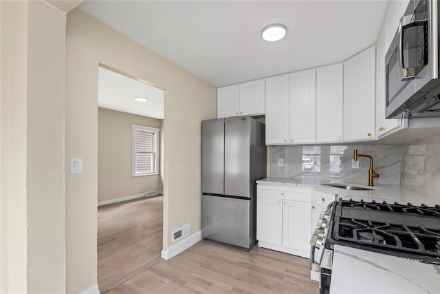 425 Quincy Ave, Bronx, NY 10465 - kitchen with appliances with stainless steel finishes, a sink, light stone counters, and white cabinetry