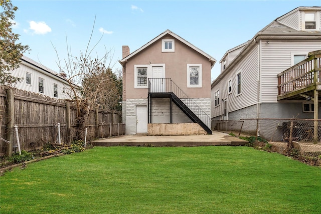 425 Quincy Ave, Bronx, NY 10465 - back of property with a chimney, a fenced backyard, stucco siding, and a lawn