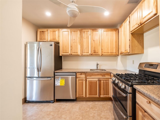 kitchen with a sink, appliances with stainless steel finishes, light brown cabinetry, and visible vents