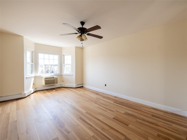 unfurnished room with baseboards, a wall unit AC, a ceiling fan, and light wood-style flooring