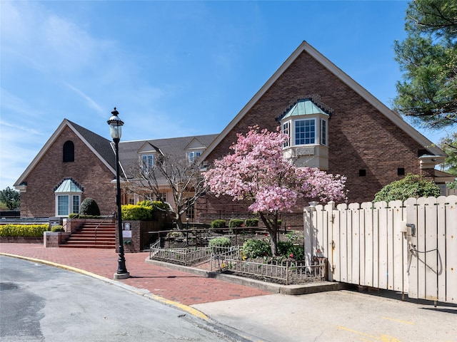 view of front of house with brick siding and fence