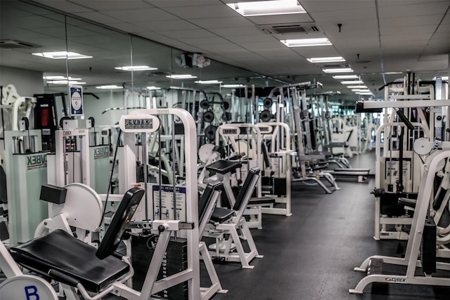 gym with a paneled ceiling and visible vents