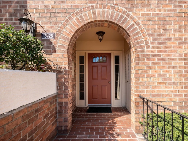 doorway to property featuring brick siding