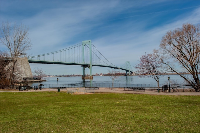 view of property's community featuring a yard, a water view, and fence