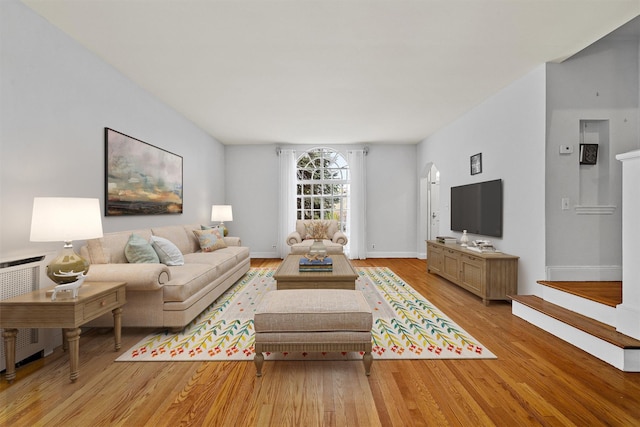 living area featuring light wood-style flooring, radiator, and baseboards
