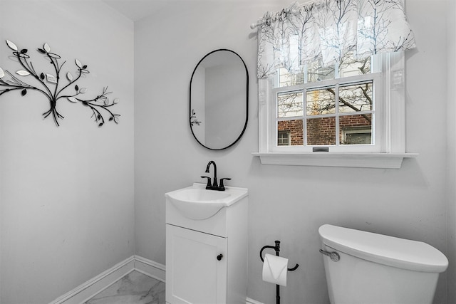 bathroom with toilet, marble finish floor, baseboards, and vanity