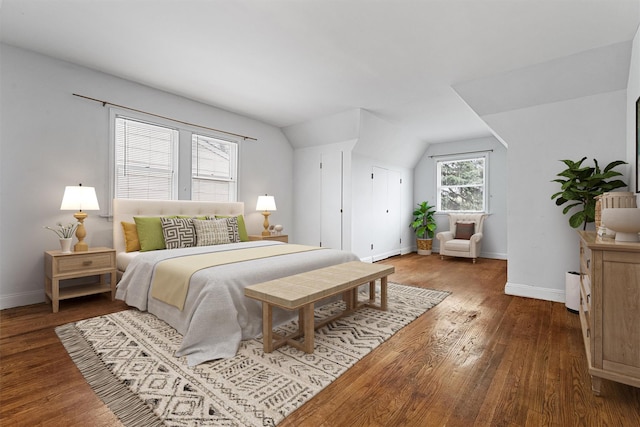 bedroom featuring wood finished floors, baseboards, and vaulted ceiling