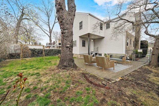 rear view of property with an outdoor living space, a patio area, fence, and a lawn