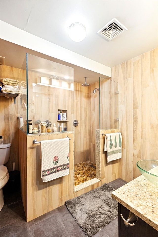 bathroom featuring visible vents, toilet, and a walk in shower