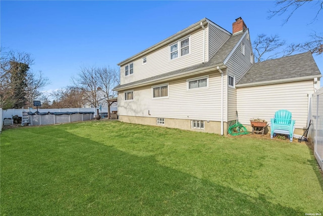 24 Southwood Ln, North Babylon, NY 11703 - back of property with roof with shingles, a chimney, a lawn, and a covered pool