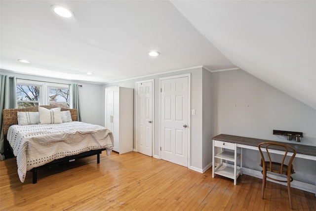 24 Southwood Ln, North Babylon, NY 11703 - bedroom featuring recessed lighting, lofted ceiling, multiple closets, light wood-style floors, and baseboards