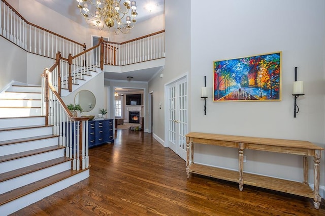 entrance foyer with a high ceiling, wood finished floors, baseboards, and stairway