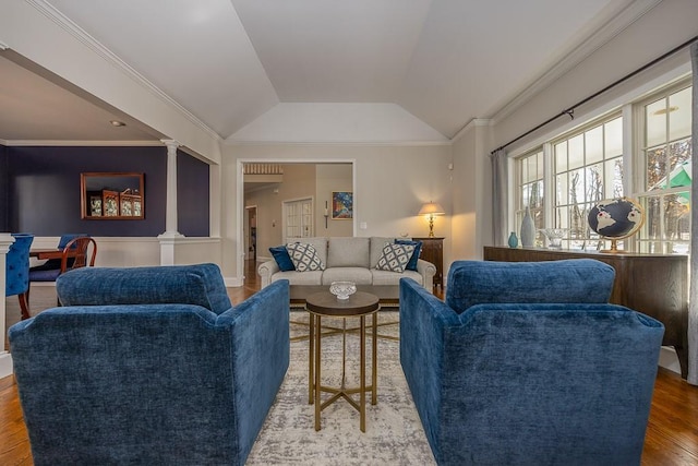 living room with ornamental molding, decorative columns, wood finished floors, and lofted ceiling