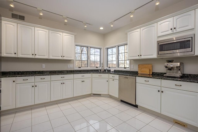 kitchen with a sink, visible vents, white cabinets, and stainless steel appliances