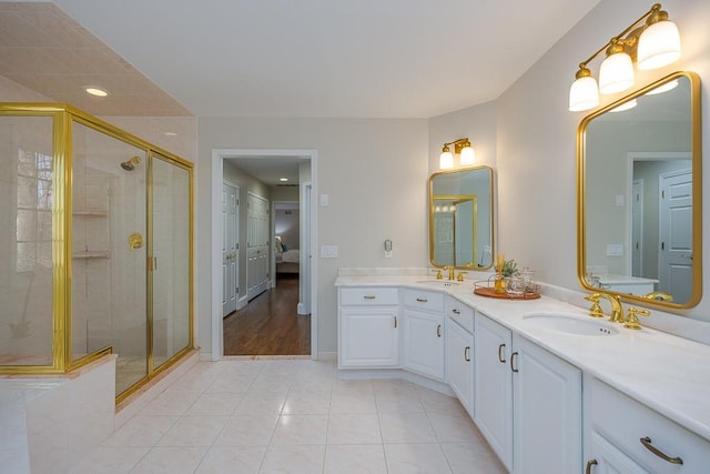 ensuite bathroom with tile patterned flooring, double vanity, a sink, and a stall shower