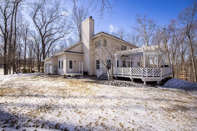 view of property exterior featuring a chimney, an attached garage, a deck, and a pergola