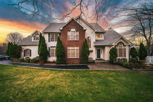 view of front of house featuring a shingled roof and a front lawn