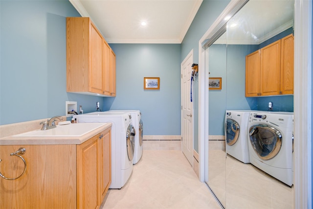 clothes washing area featuring washing machine and clothes dryer, a sink, cabinet space, crown molding, and light tile patterned floors