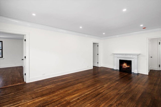 unfurnished living room featuring recessed lighting, a fireplace with flush hearth, ornamental molding, and wood finished floors