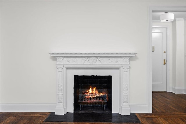 interior details with baseboards and a fireplace with flush hearth