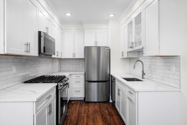 kitchen featuring stainless steel appliances, white cabinetry, and a sink