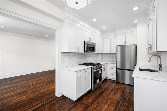 kitchen featuring crown molding, stainless steel appliances, white cabinetry, and a sink