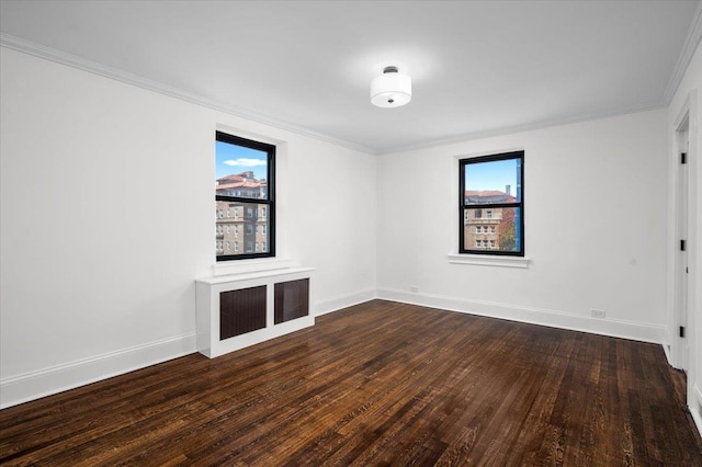 unfurnished room featuring baseboards, crown molding, and wood finished floors
