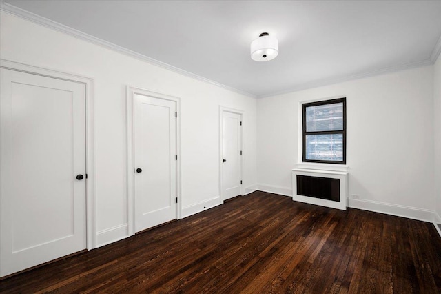 unfurnished bedroom with crown molding, dark wood-style flooring, and baseboards