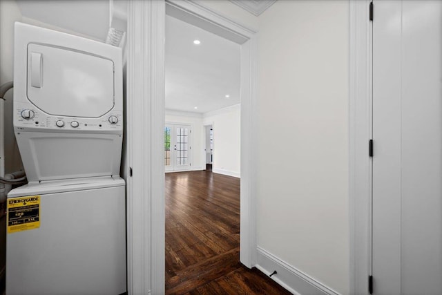 laundry room featuring parquet flooring, baseboards, ornamental molding, and stacked washer and clothes dryer