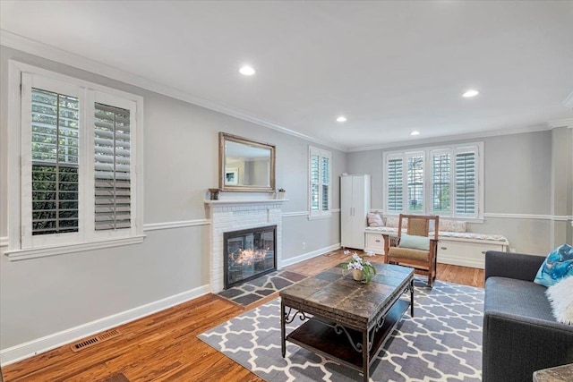 living room with visible vents, baseboards, recessed lighting, ornamental molding, and wood finished floors
