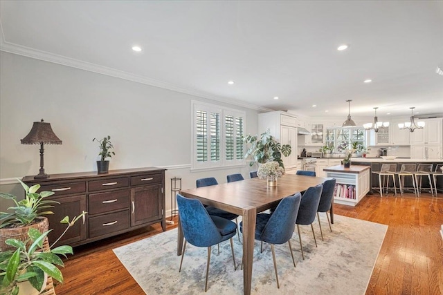 dining area with ornamental molding, recessed lighting, and light wood-style floors