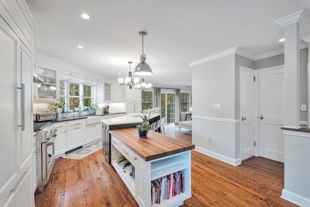 kitchen featuring high end stove, butcher block countertops, white cabinetry, and light wood-style floors