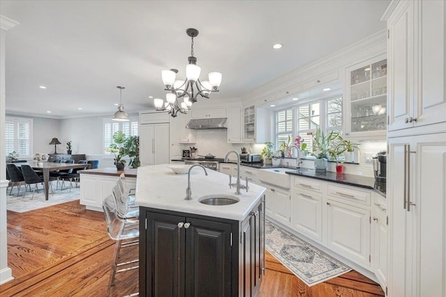 kitchen featuring an inviting chandelier, a sink, and white cabinetry