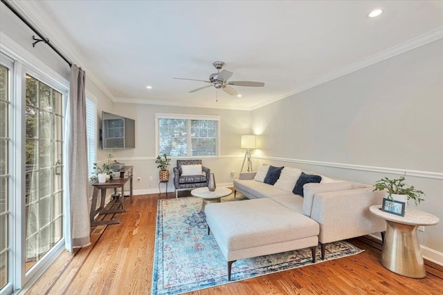living room featuring baseboards, wood finished floors, ceiling fan, and crown molding