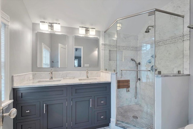 bathroom featuring double vanity, a sink, and a shower stall