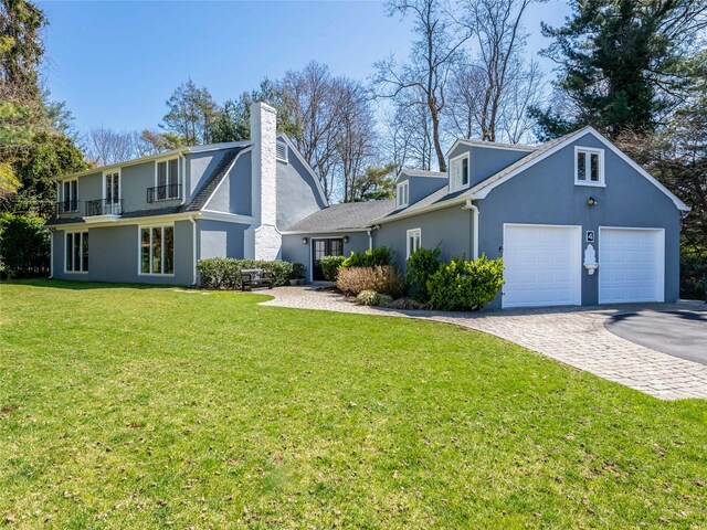 4 Terrace Ct, Port Washington, NY 11050 - view of front of home with a garage, driveway, stucco siding, a front yard, and a balcony