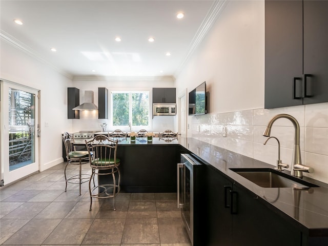 4 Terrace Ct, Port Washington, NY 11050 - kitchen featuring dark cabinets, a sink, beverage cooler, backsplash, and stainless steel microwave